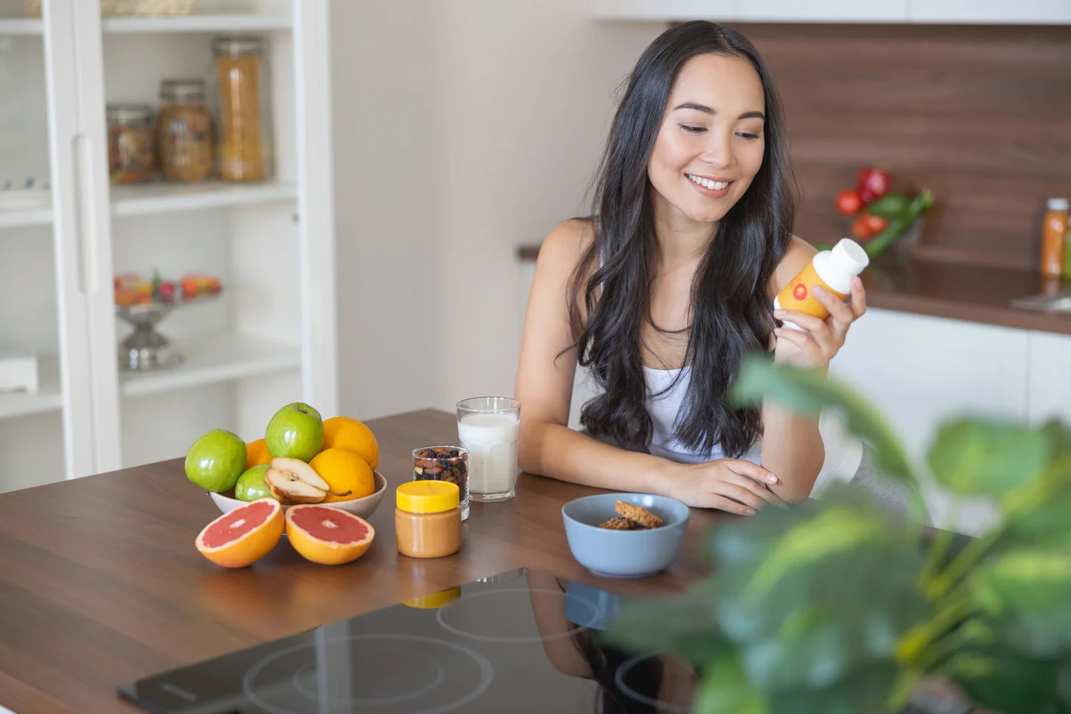 Woman reviewing a wellness supplement in a bright kitchen